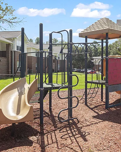 Inviting playground area with slides and climbing structures set against residential buildings, perfect for family living.