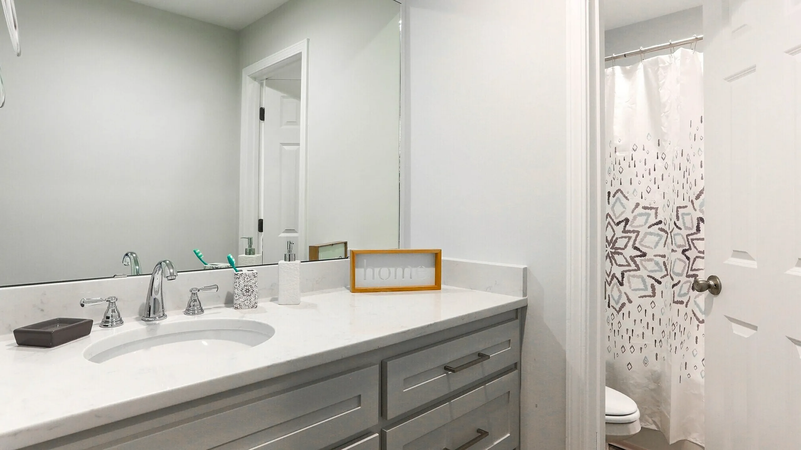 Contemporary bathroom with elegant white countertop, stylish fixtures, and decorative accents, providing a serene atmosphere.