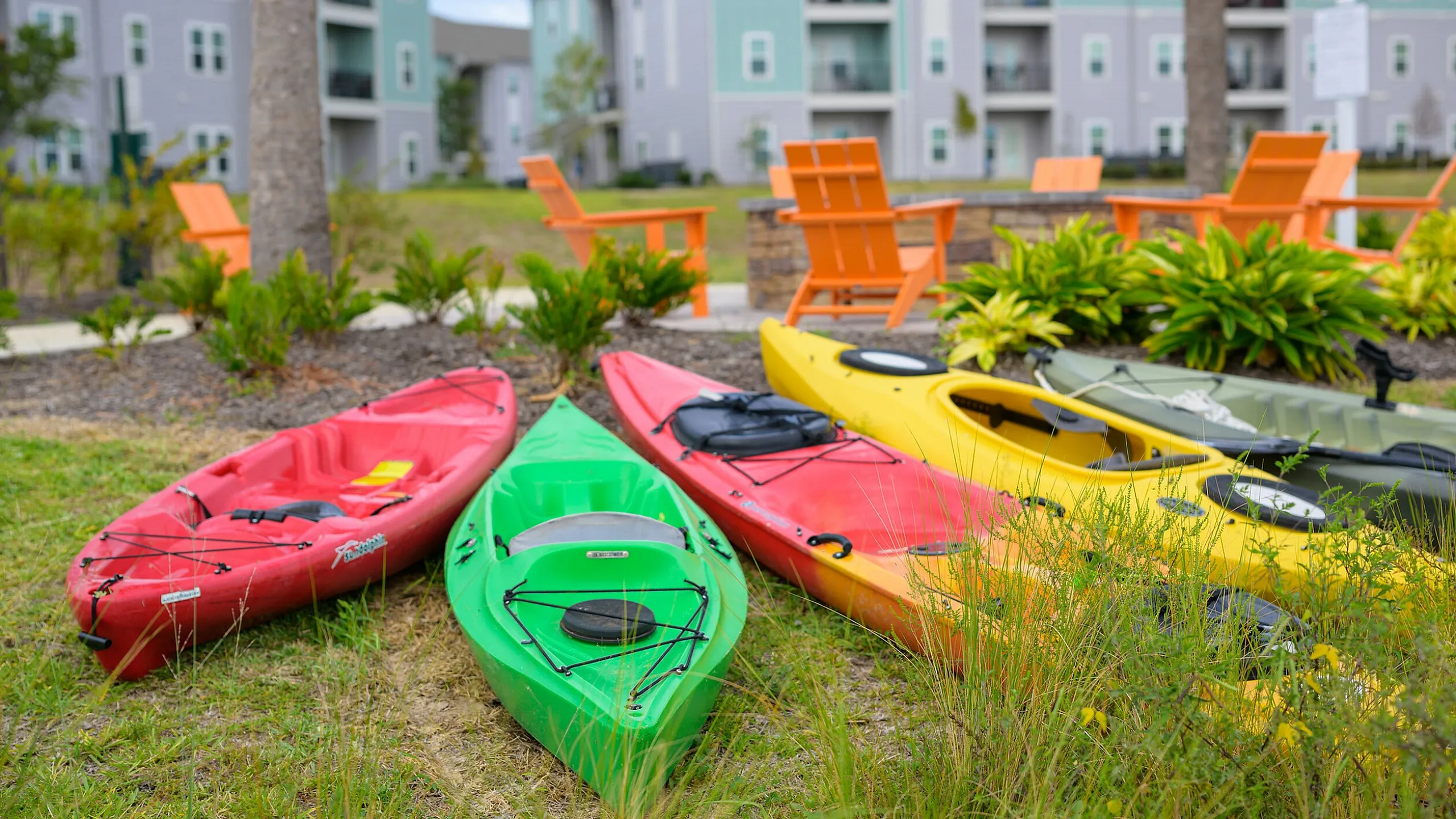 Vibrant outdoor space with colorful kayaks and modern apartment buildings in the background, offering a perfect blend of adventure and urban living.