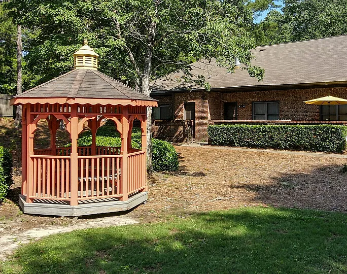 Charming outdoor area with a rustic gazebo and well-maintained garden, perfect for relaxation and gatherings.