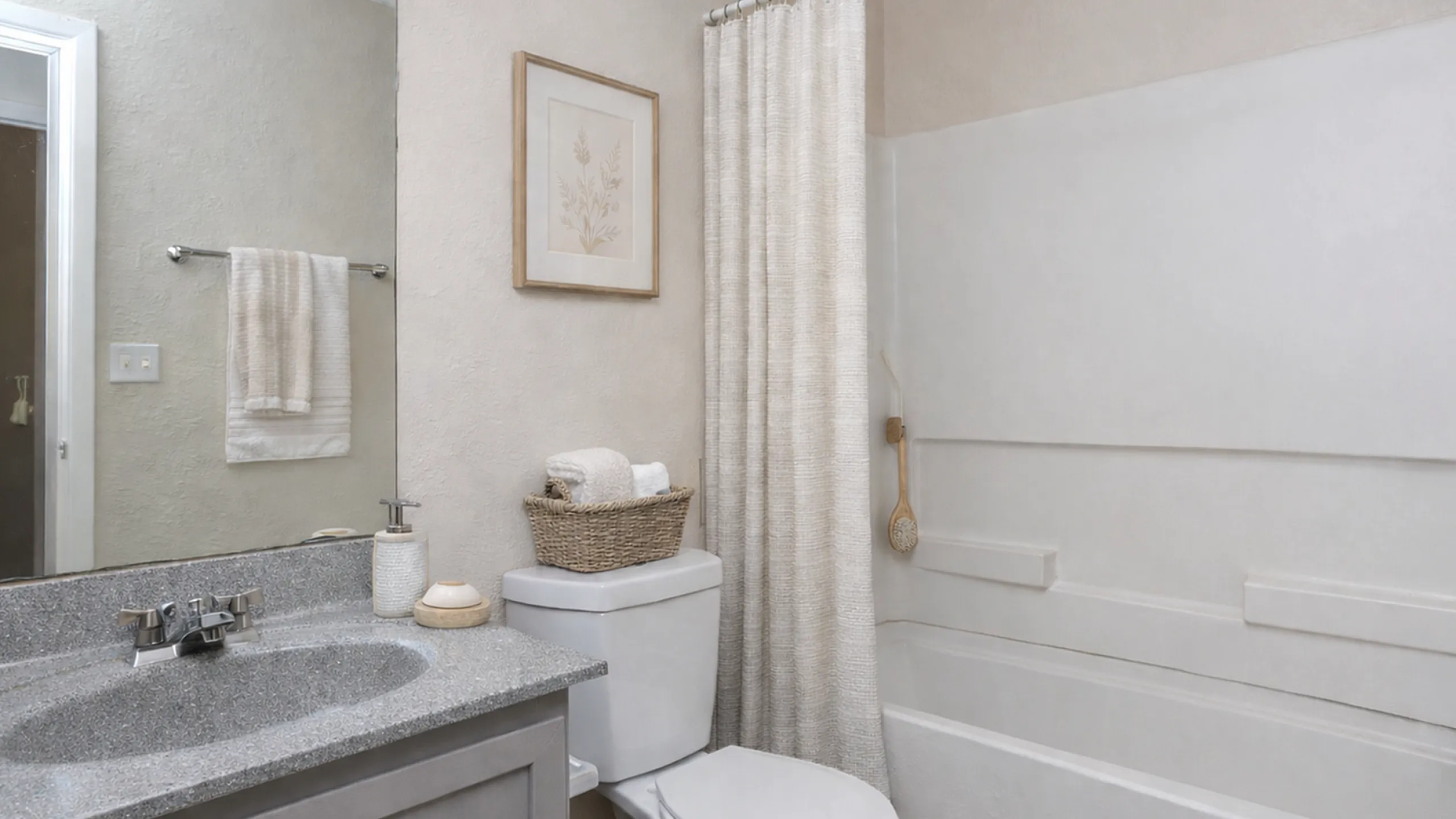 Elegant bathroom with a modern sink, decorative artwork, and sophisticated bath accessories for a serene atmosphere.