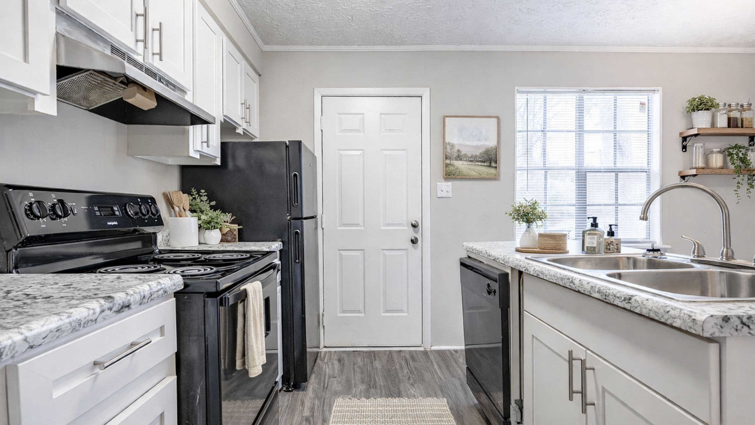 Chic kitchen featuring elegant marble countertops, modern appliances, and ample natural light for a welcoming atmosphere.