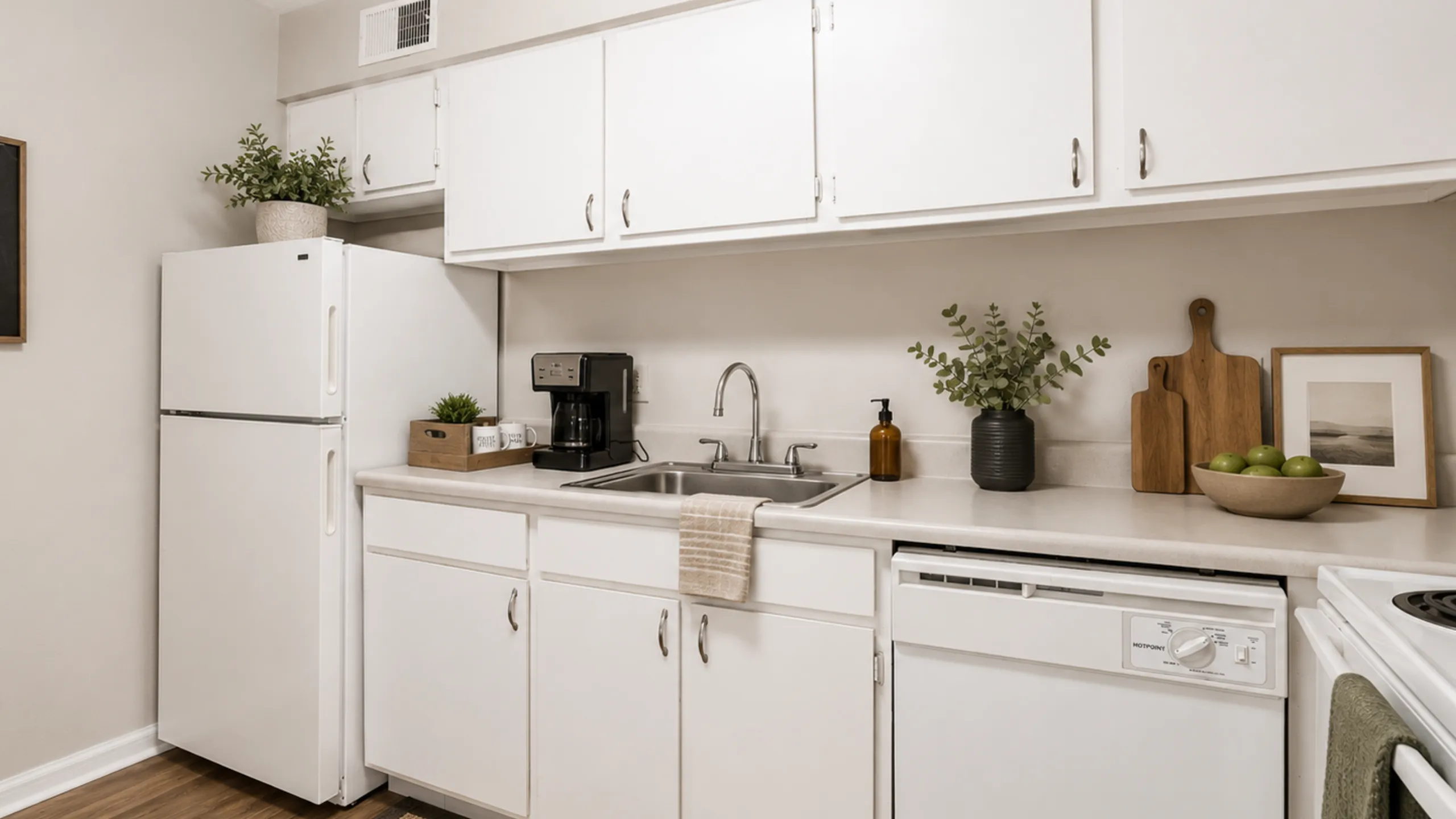 Charming kitchen with sleek white cabinetry, modern appliances, and tasteful decor, creating a warm and inviting space.
