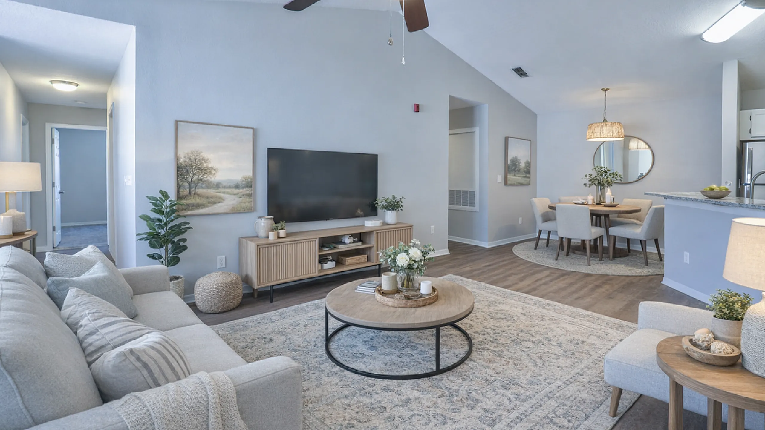 Elegant open-concept living and dining area with modern decor, cozy sectional sofa, stylish coffee table, and inviting dining set, perfect for entertaining.