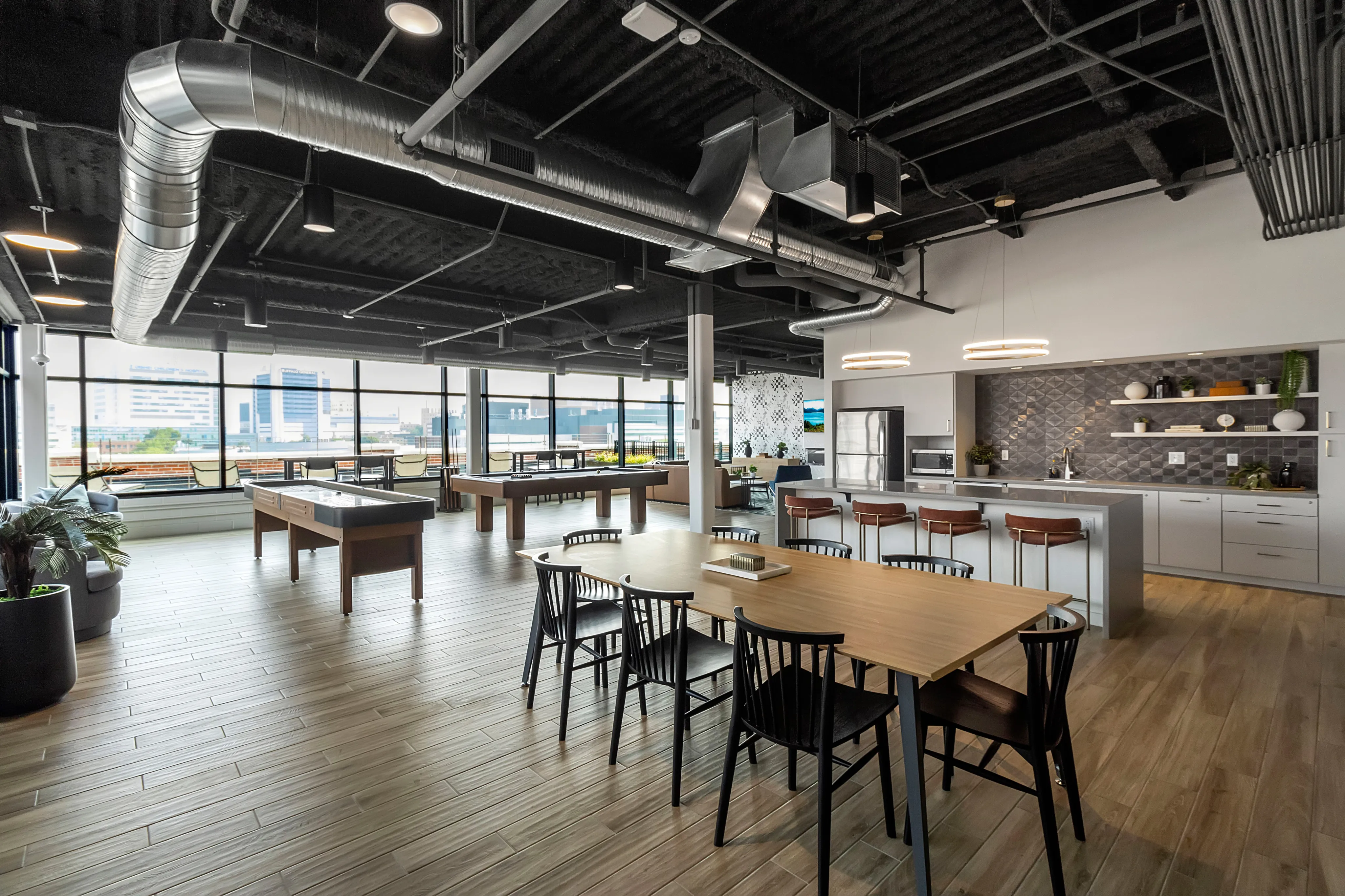 Sleek open-plan loft with modern furnishings, expansive windows, and spacious kitchen, ideal for stylish urban living.