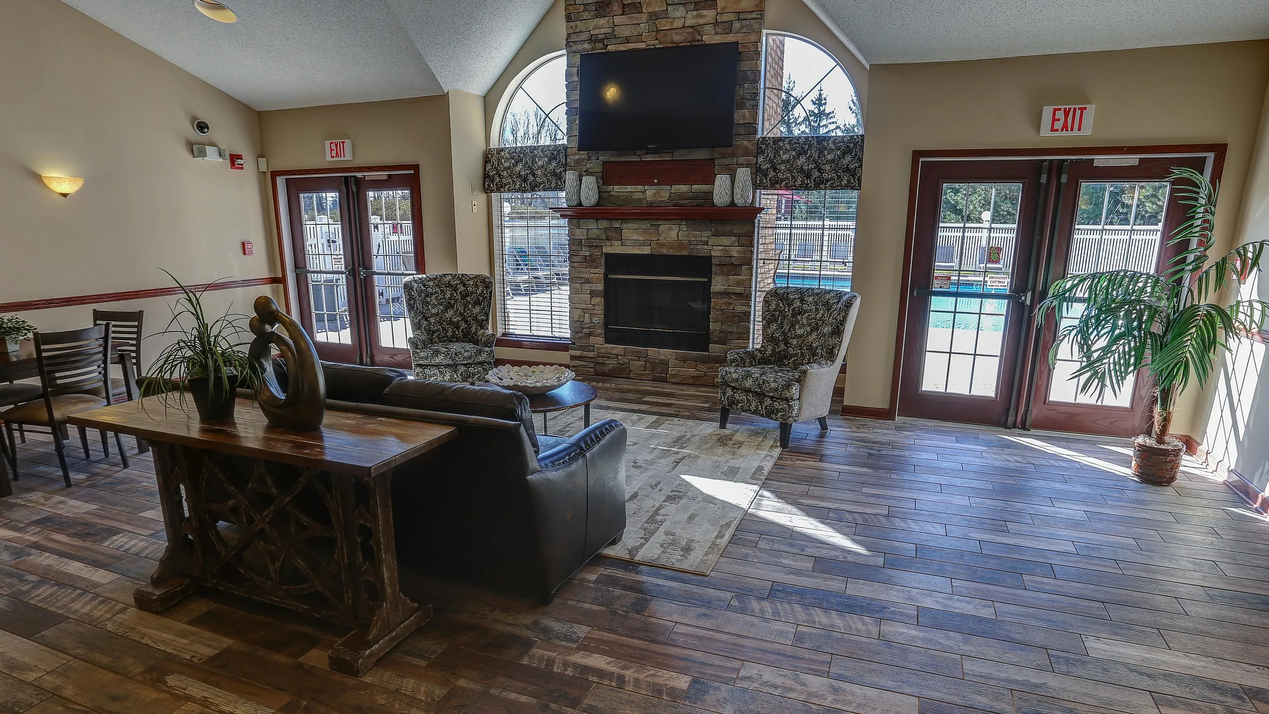 Inviting living room with elegant stone fireplace, natural light from large windows, and chic modern decor, perfect for relaxation and gatherings.