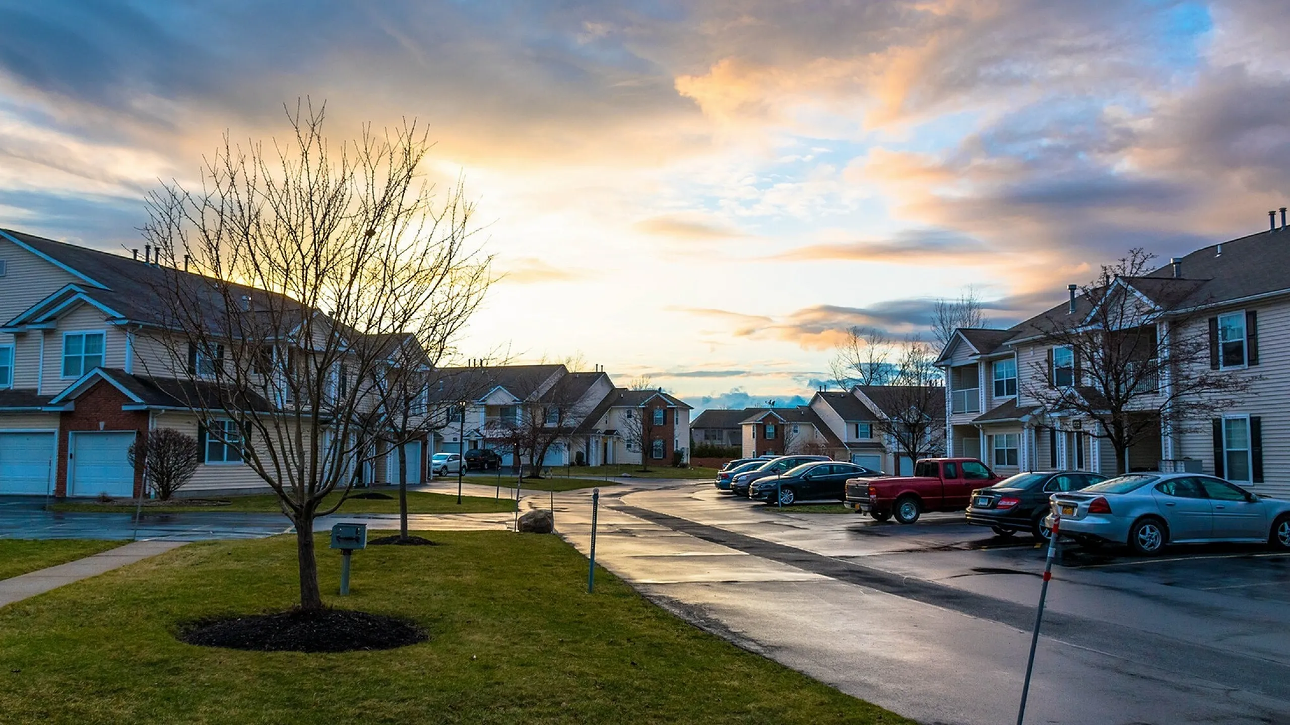 Charming suburban neighborhood at sunset, showcasing modern townhouses and an inviting community feel.