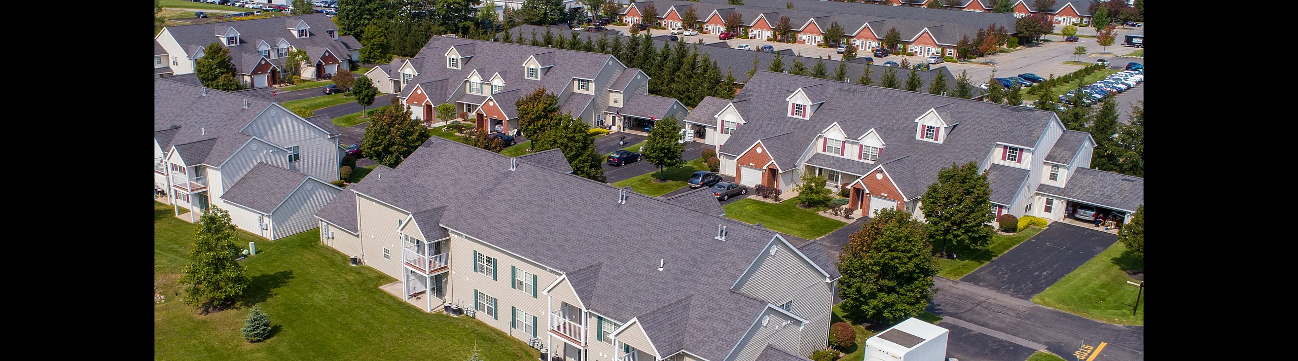 Charming suburban townhouse community with landscaped lawns, ample parking, and scenic views.