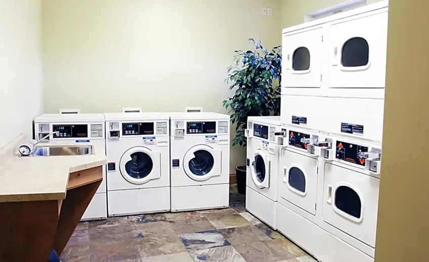 Laundry room with 4 washing machines, 4 dryers, and sink