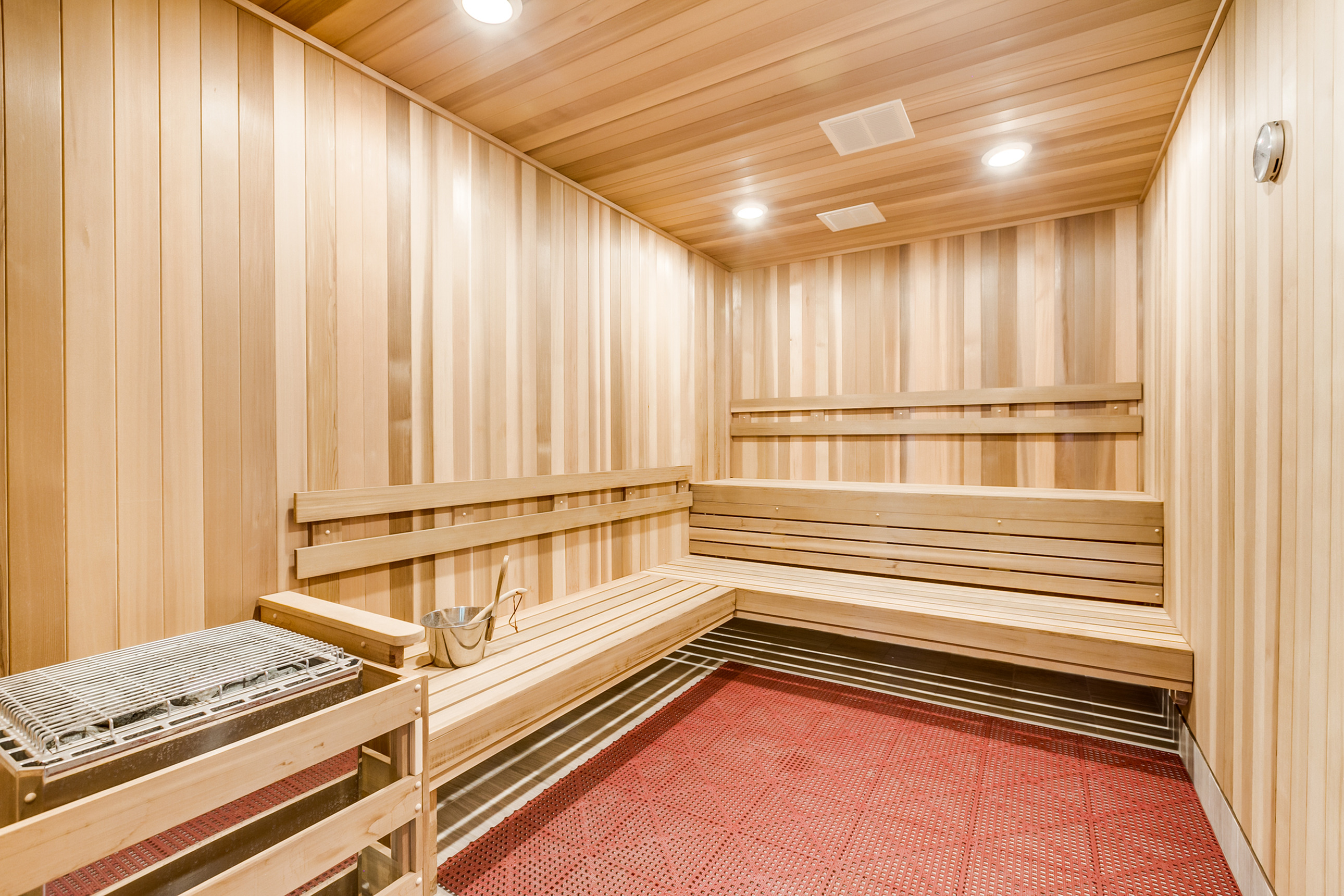 Luxurious cedar sauna featuring warm wood paneling, ambient lighting, and a comfortable bench seating area.