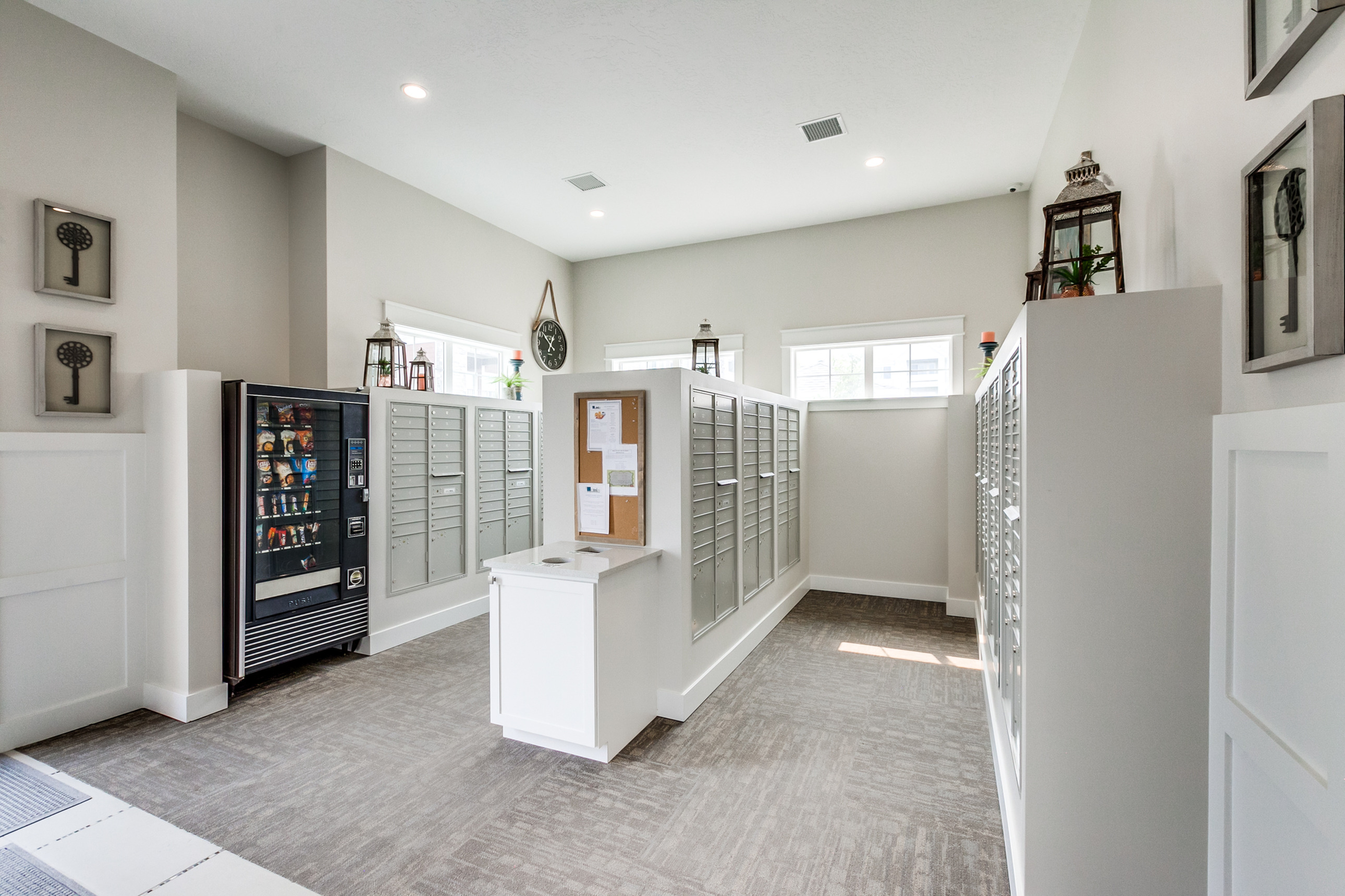 Bright and modern mailroom with organized mailboxes and a convenient snack vending machine, offering a welcoming community atmosphere.