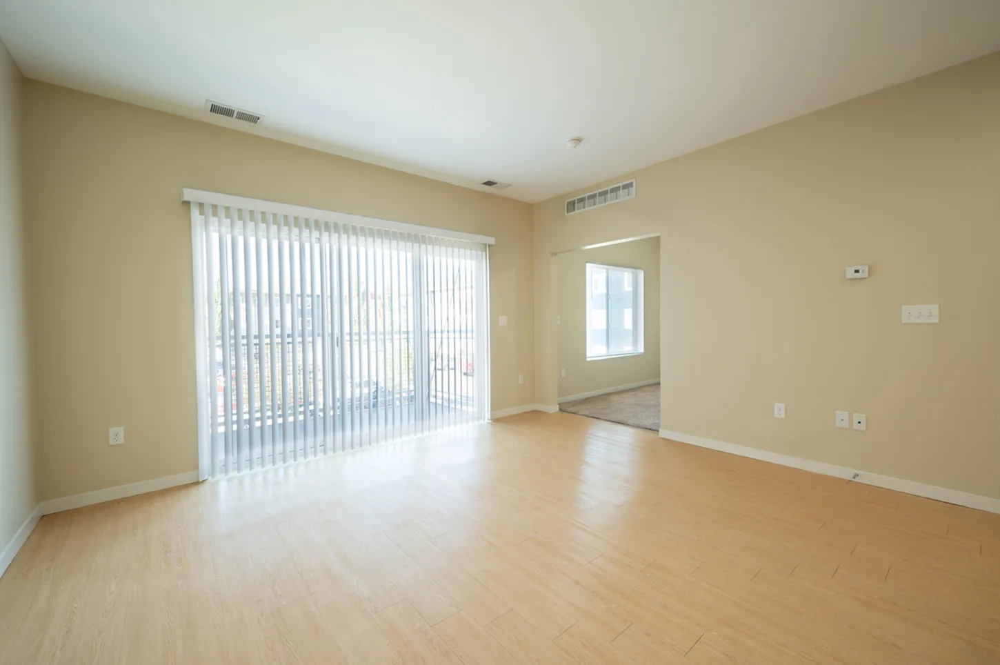 Bright and airy living room with large sliding glass doors, natural light, and elegant hardwood floors.