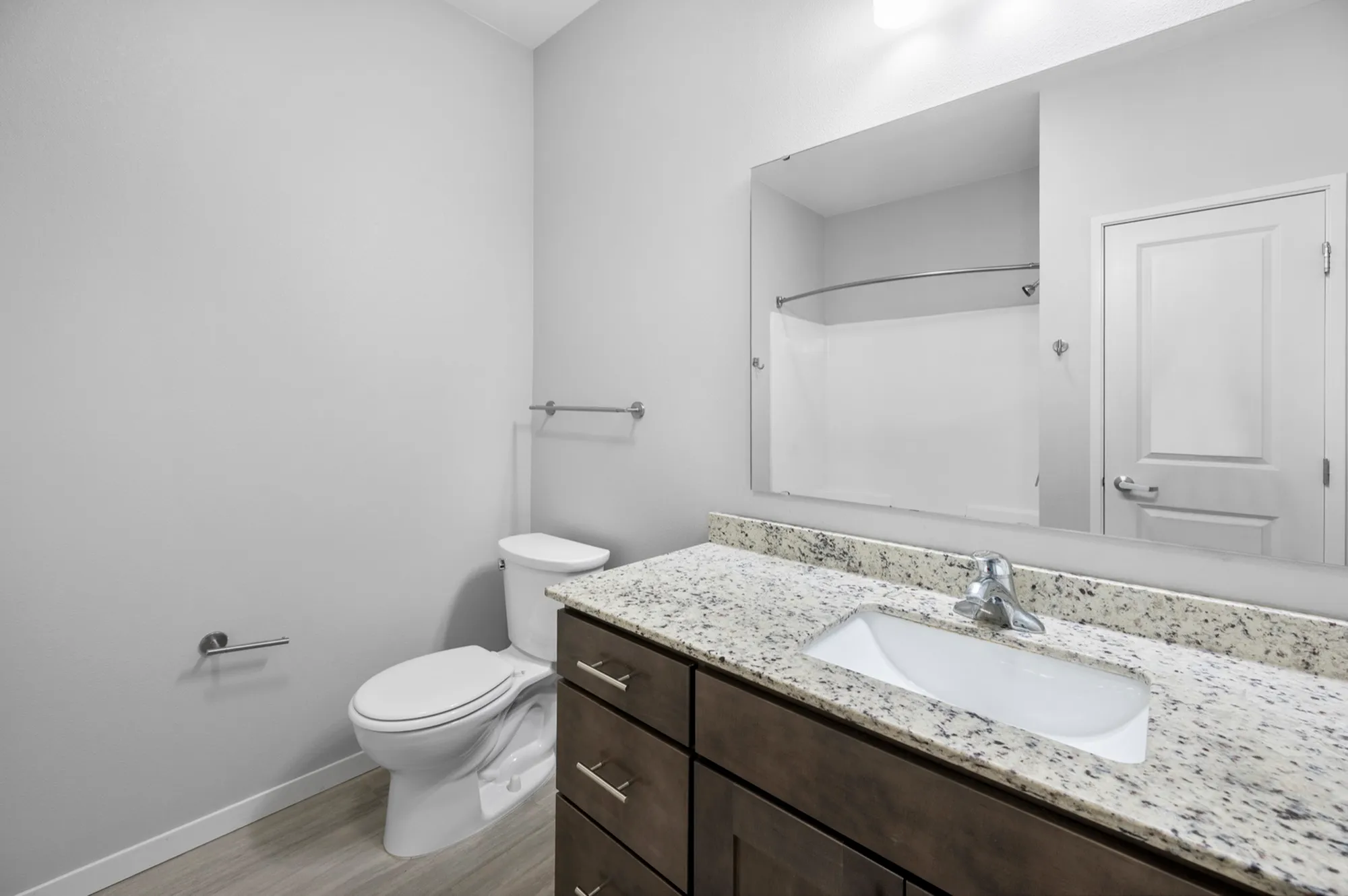Modern bathroom with granite countertop, sleek fixtures, and elegant neutral tones for a sophisticated feel.