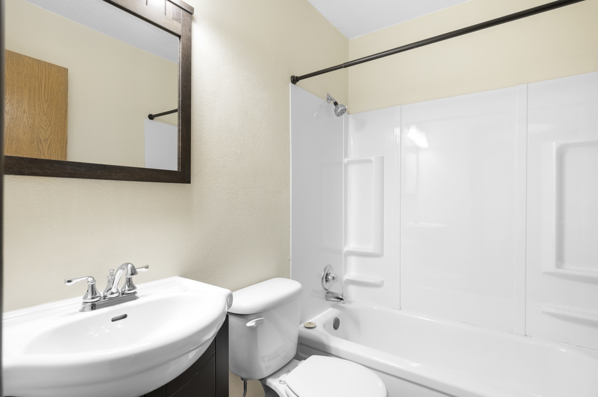Bright and modern bathroom with sleek white fixtures, featuring a spacious bathtub and elegant mirror.