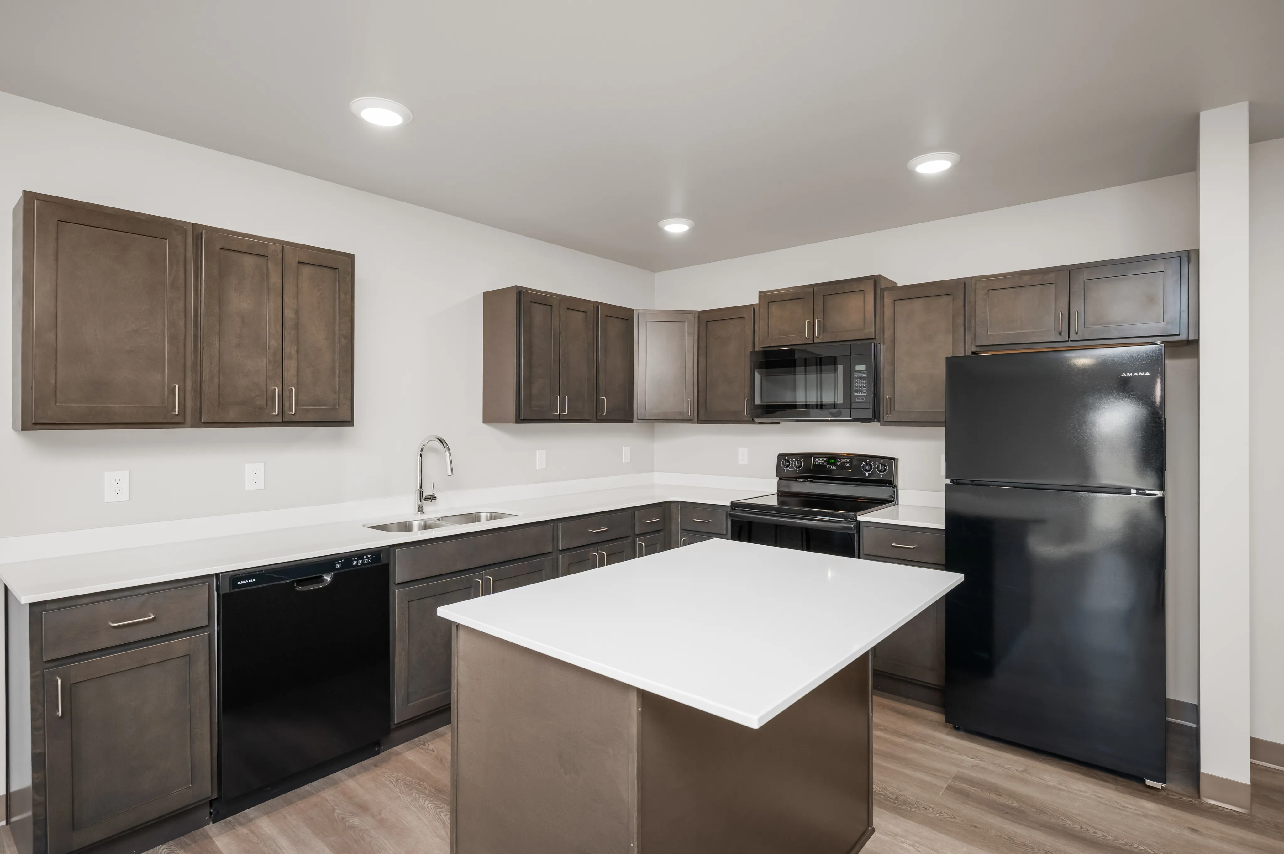 Modern kitchen with sleek dark cabinetry, spacious counters, and an island centerpiece, ideal for entertaining.