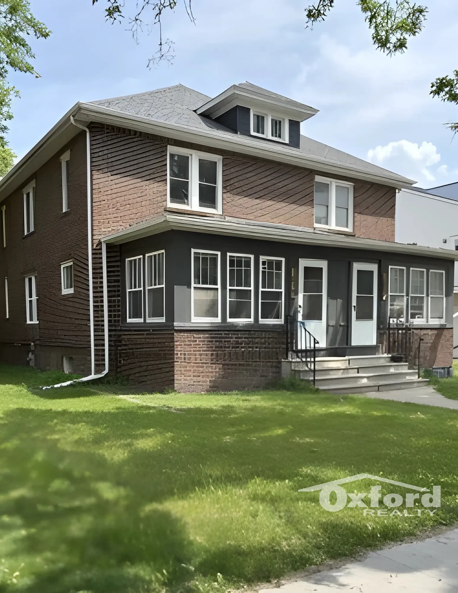 Charming two-story brick home with a classic design, large windows, and a well-maintained front lawn, perfect for family living.
