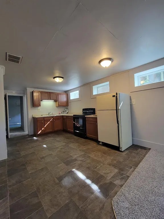 Charming kitchen area with modern cabinets, ample natural light, and sleek appliances creating a warm, inviting space.