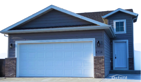 Charming modern home with spacious two-car garage and vibrant blue facade, ideal for family living.