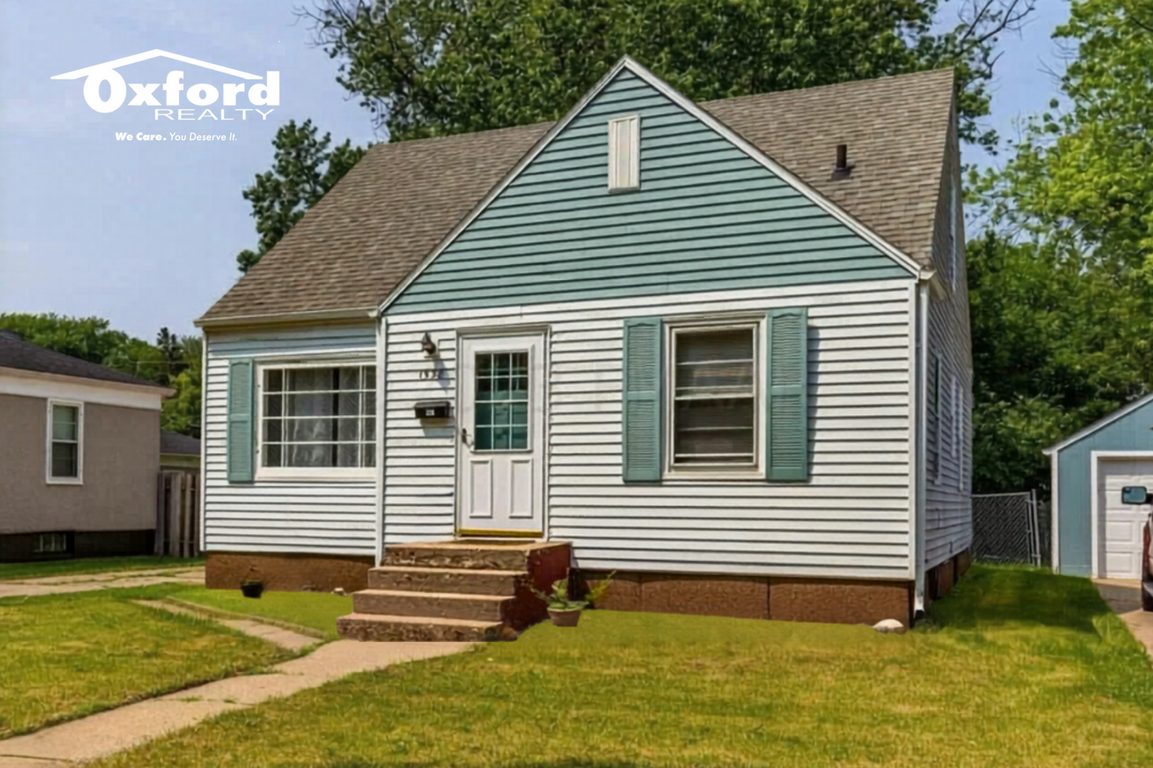 Charming single-story home with blue siding, inviting front steps, and a well-kept lawn, perfect for cozy living.