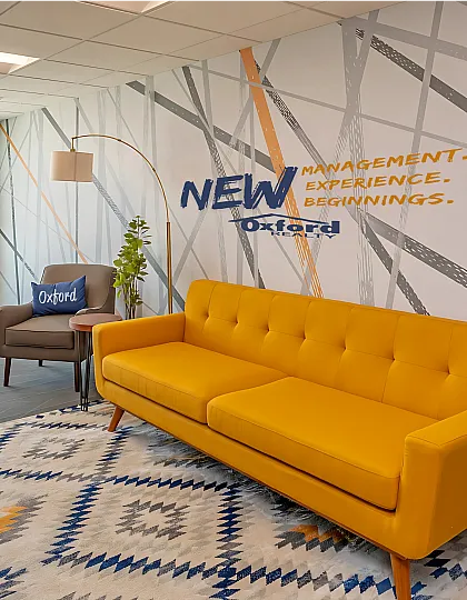 Contemporary lounge area with a vibrant yellow sofa, elegant armchair, and stylish decor, perfect for modern living experiences.