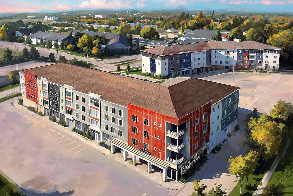Vibrant aerial view of modern apartment complex with colorful facades, ample parking, and lush surroundings, offering a perfect blend of urban living and natural beauty.