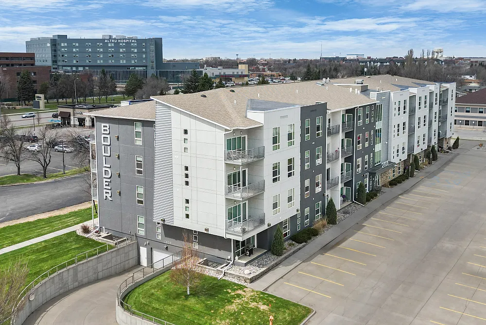 Contemporary apartment complex with eye-catching design, ample parking, and lush green surroundings.