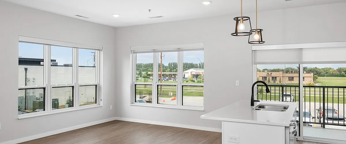Bright and modern apartment with an open-concept kitchen, large windows, and a scenic balcony view.