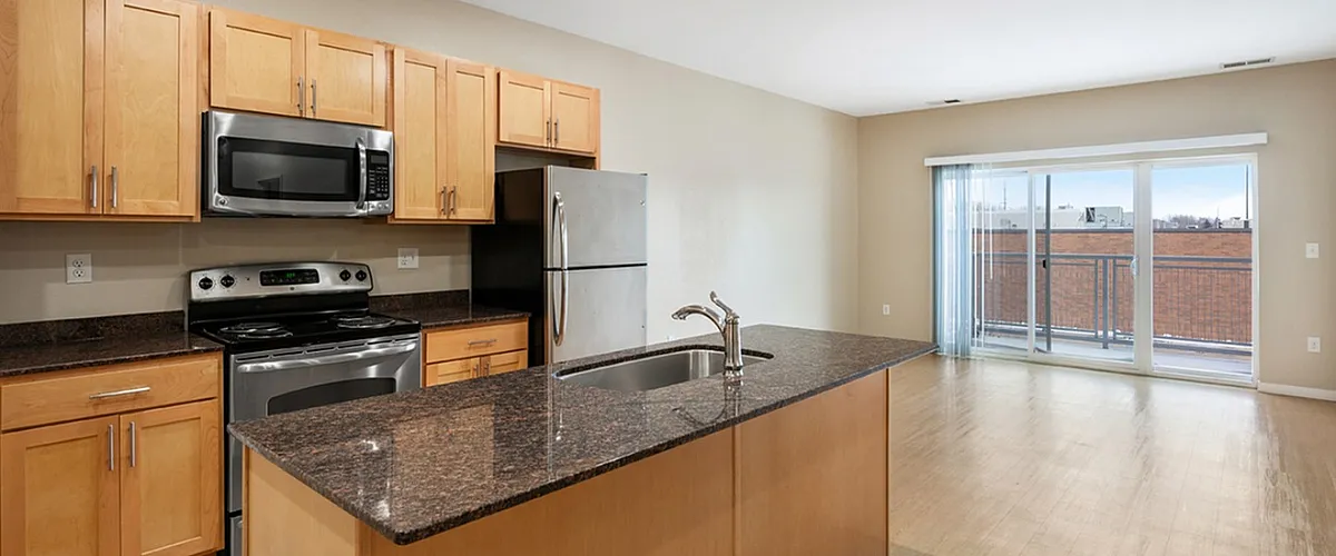 Modern apartment with sleek open-plan kitchen, granite countertops, and floor-to-ceiling windows for abundant natural light.