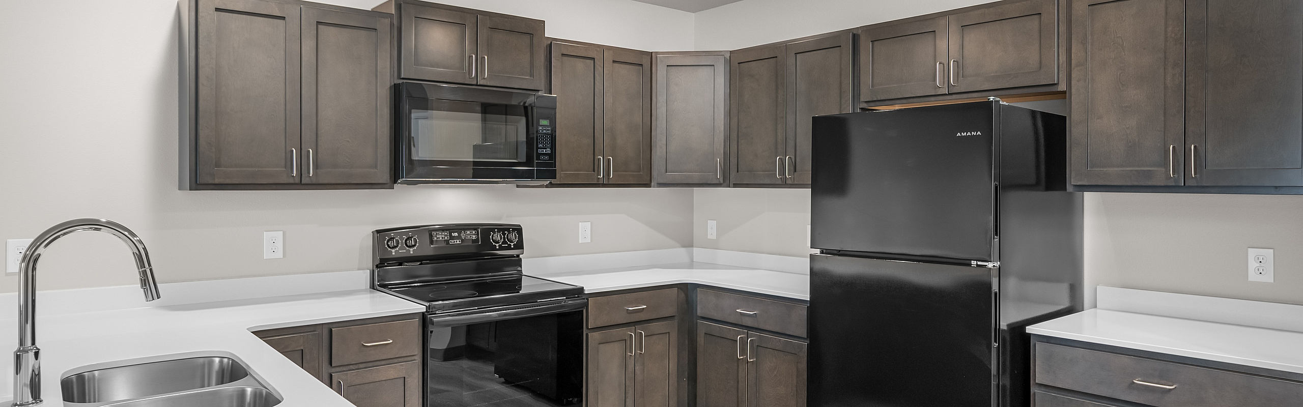 Modern kitchen with sleek black appliances, elegant wooden cabinets, and a bright, inviting atmosphere.