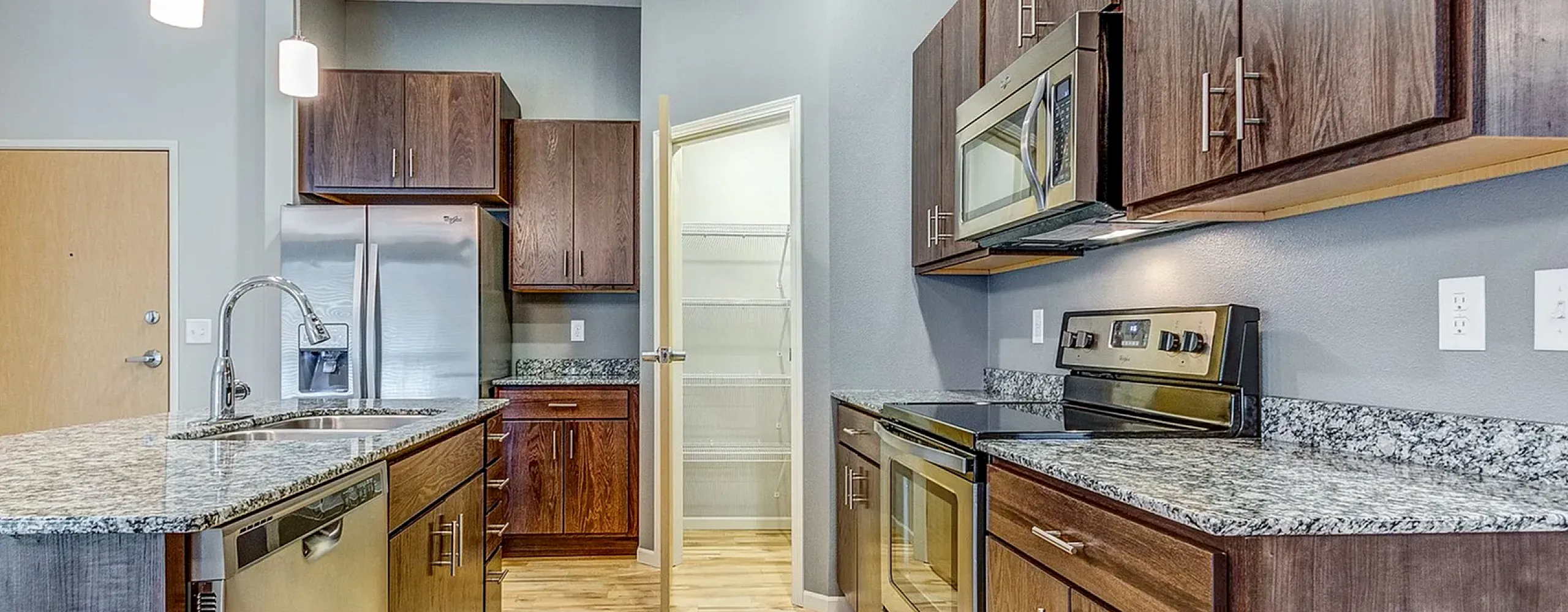 Contemporary kitchen featuring granite countertops, modern stainless steel appliances, and elegant pendant lighting, ideal for culinary enthusiasts.