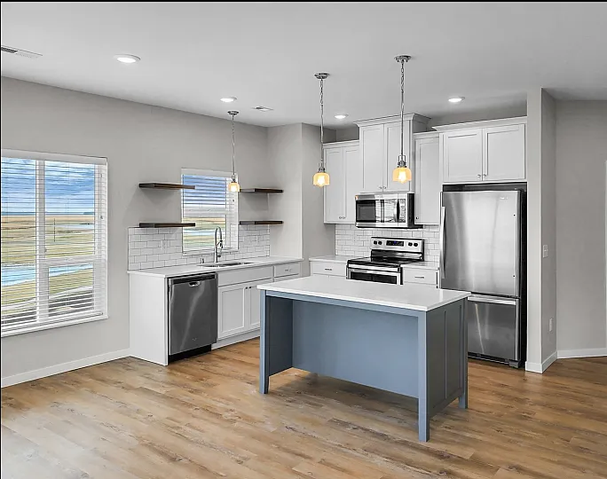 Bright and modern kitchen with sleek stainless steel appliances, elegant white cabinetry, and a spacious island perfect for gatherings.
