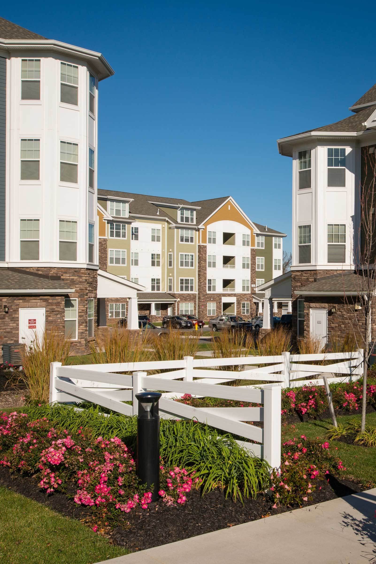 Community view with landscaping, flowers, and view of garden style apartments.