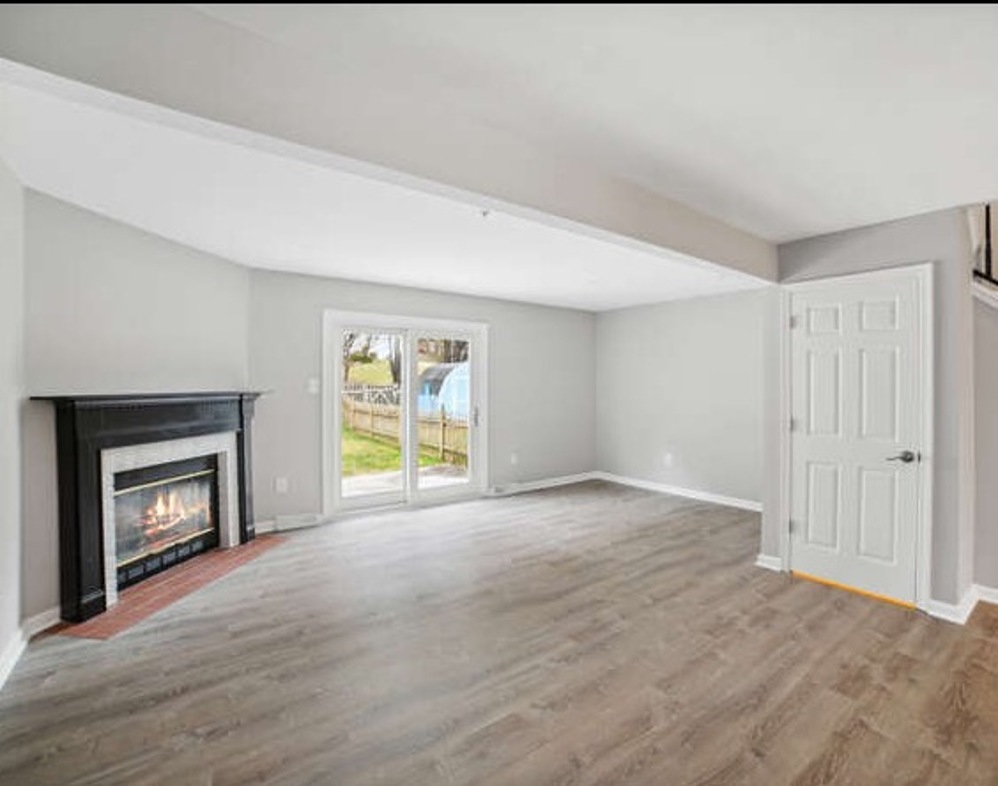 Renovated living area with fireplace & paned sliding doors to a private patio & backyard at 6306 Jacobs Court in Eldersburg, MD