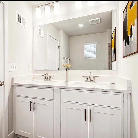 Sleek modern bathroom with double vanity, large mirror, and stylish lighting.