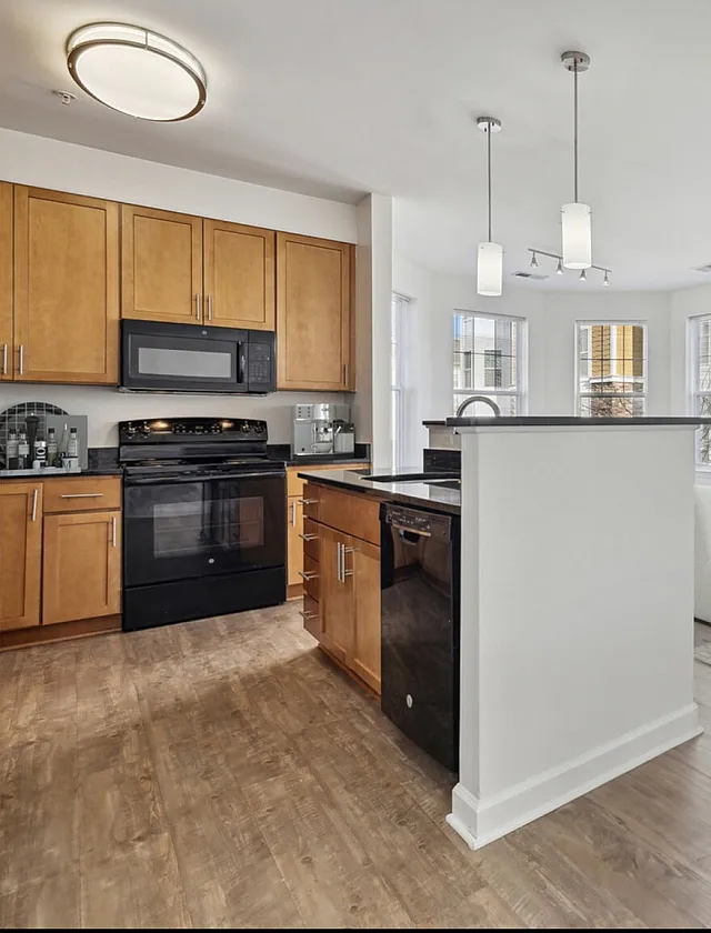 Bright and elegant open-concept living room and kitchen with sleek countertops, modern lighting, and chic d&eacute;cor.