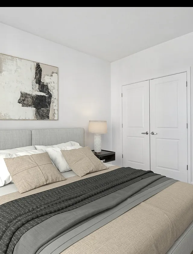 Contemporary bedroom with chic minimalist decor, featuring a cozy bed, modern artwork, and ample natural light.
