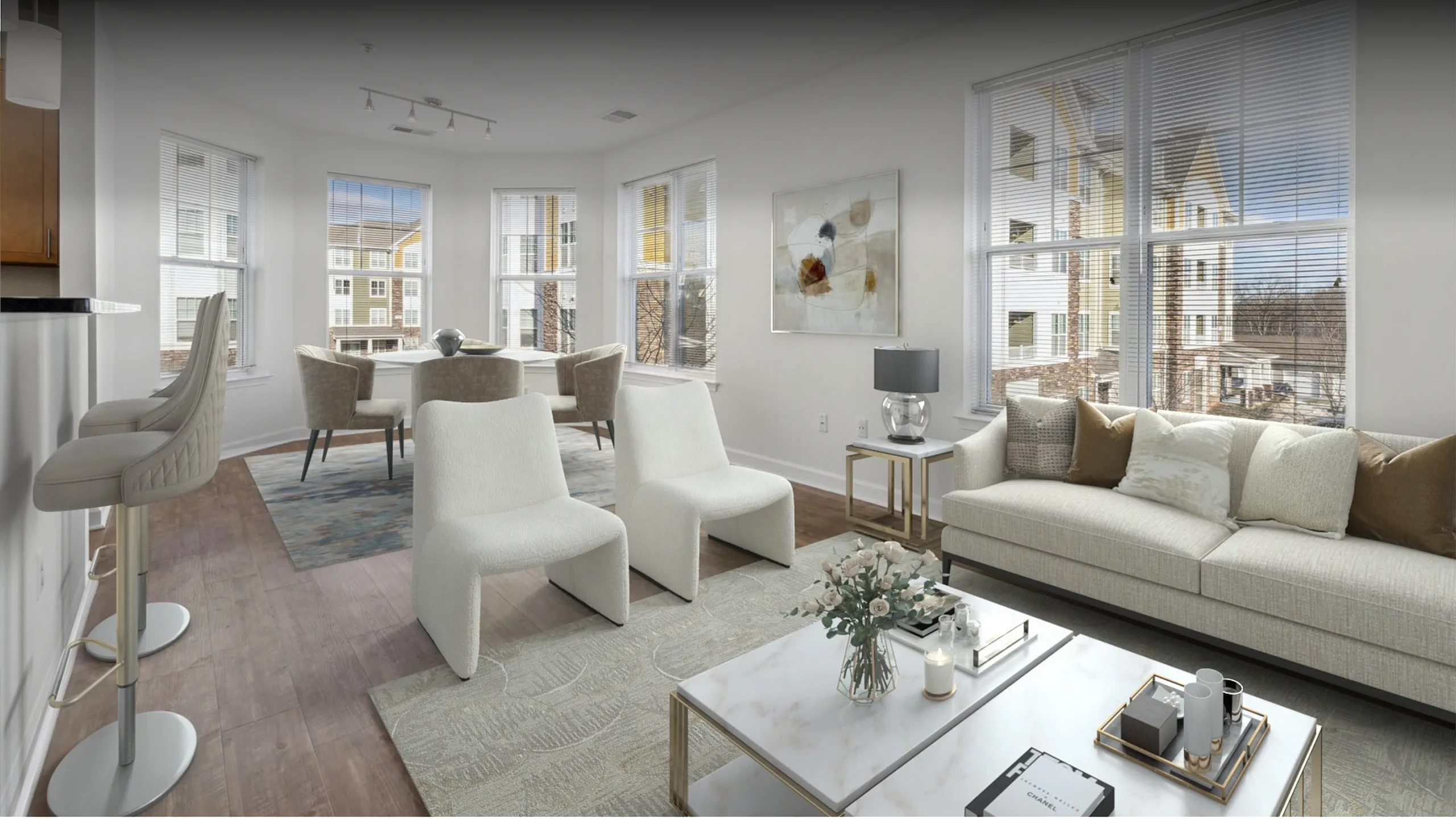 Bright and modern living area with elegant decor, featuring a cozy sofa, stylish armchairs, and a chic dining set, complemented by large windows that offer plenty of natural light.
