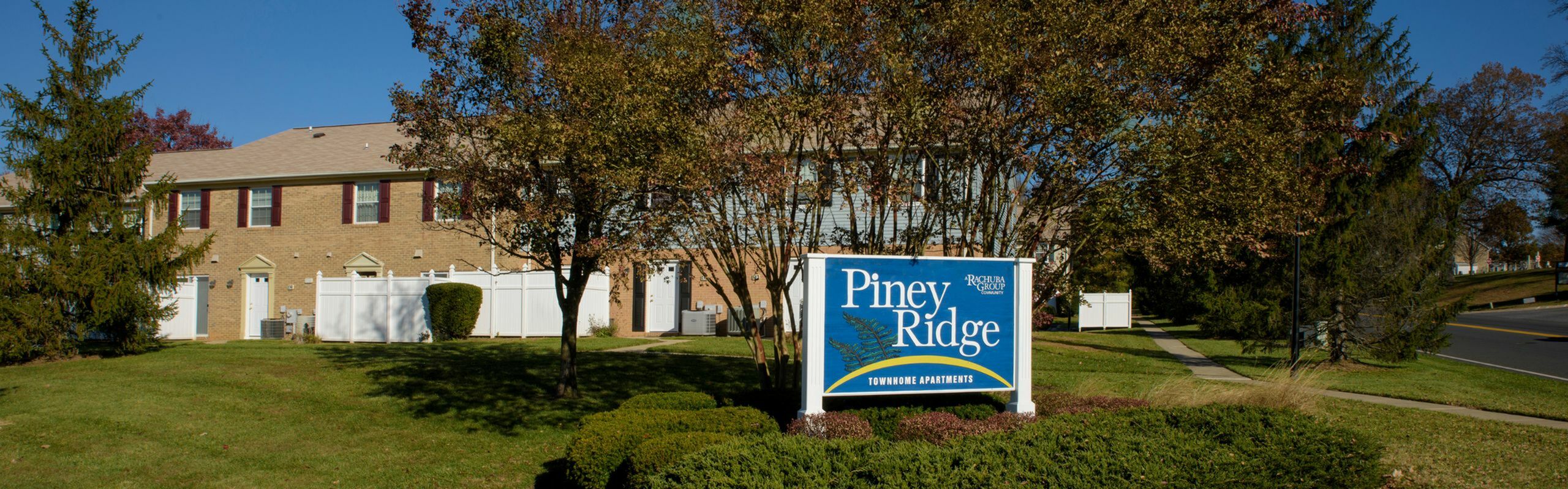 Charming Piney Ridge townhome apartments nestled among lush greenery, offering a serene and inviting community ambiance.