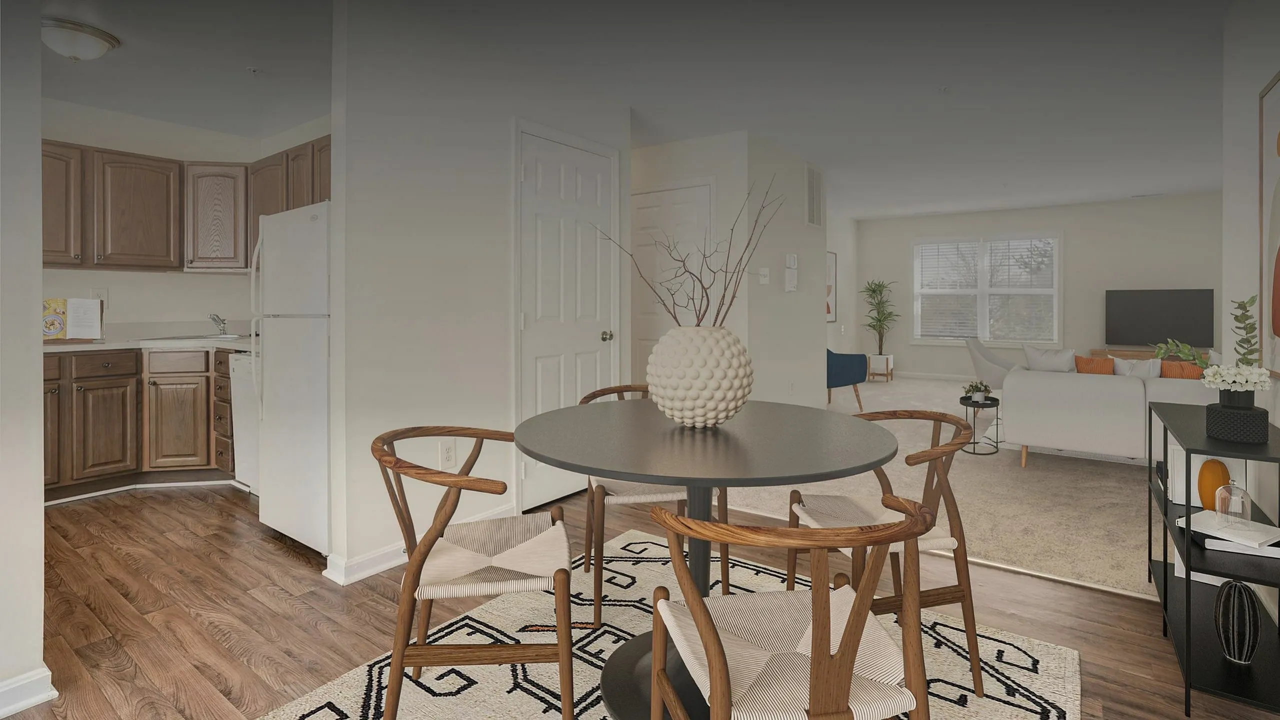 Inviting open-concept living space with elegant wood flooring, modern kitchen, and stylish dining area leading to a cozy living room.