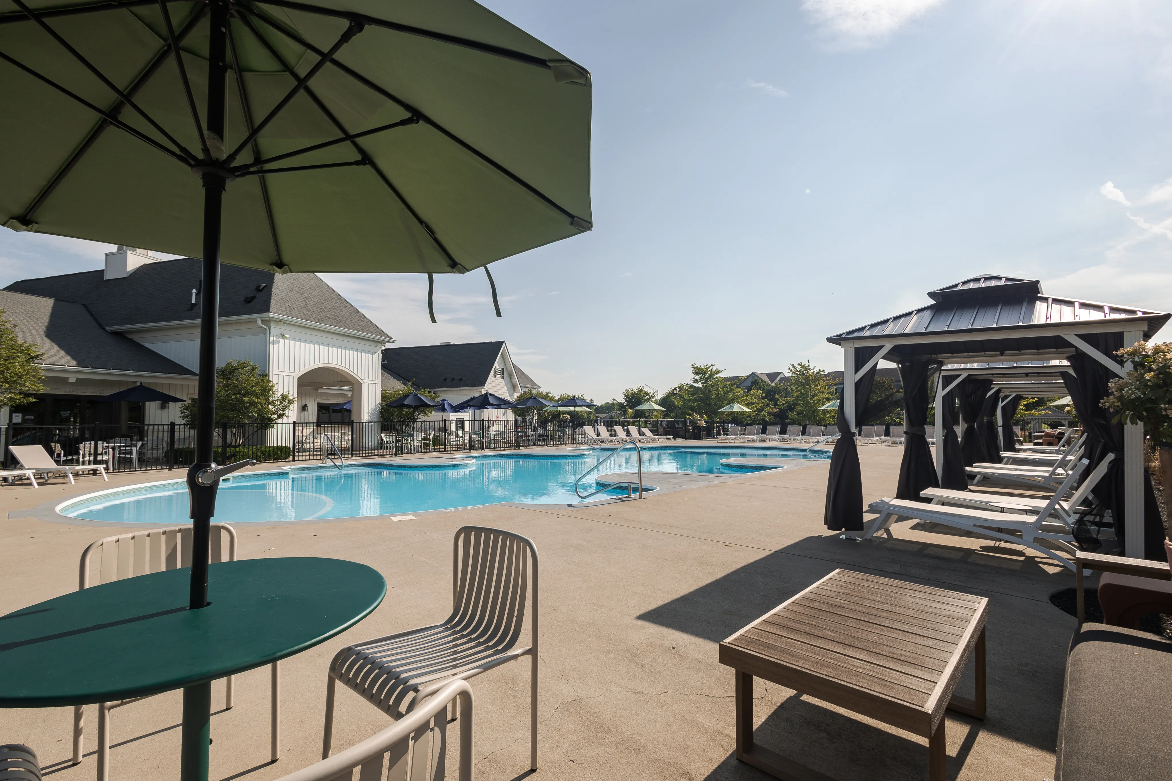 Luxurious outdoor pool area with stylish cabanas, sun loungers, and shaded seating perfect for relaxation.