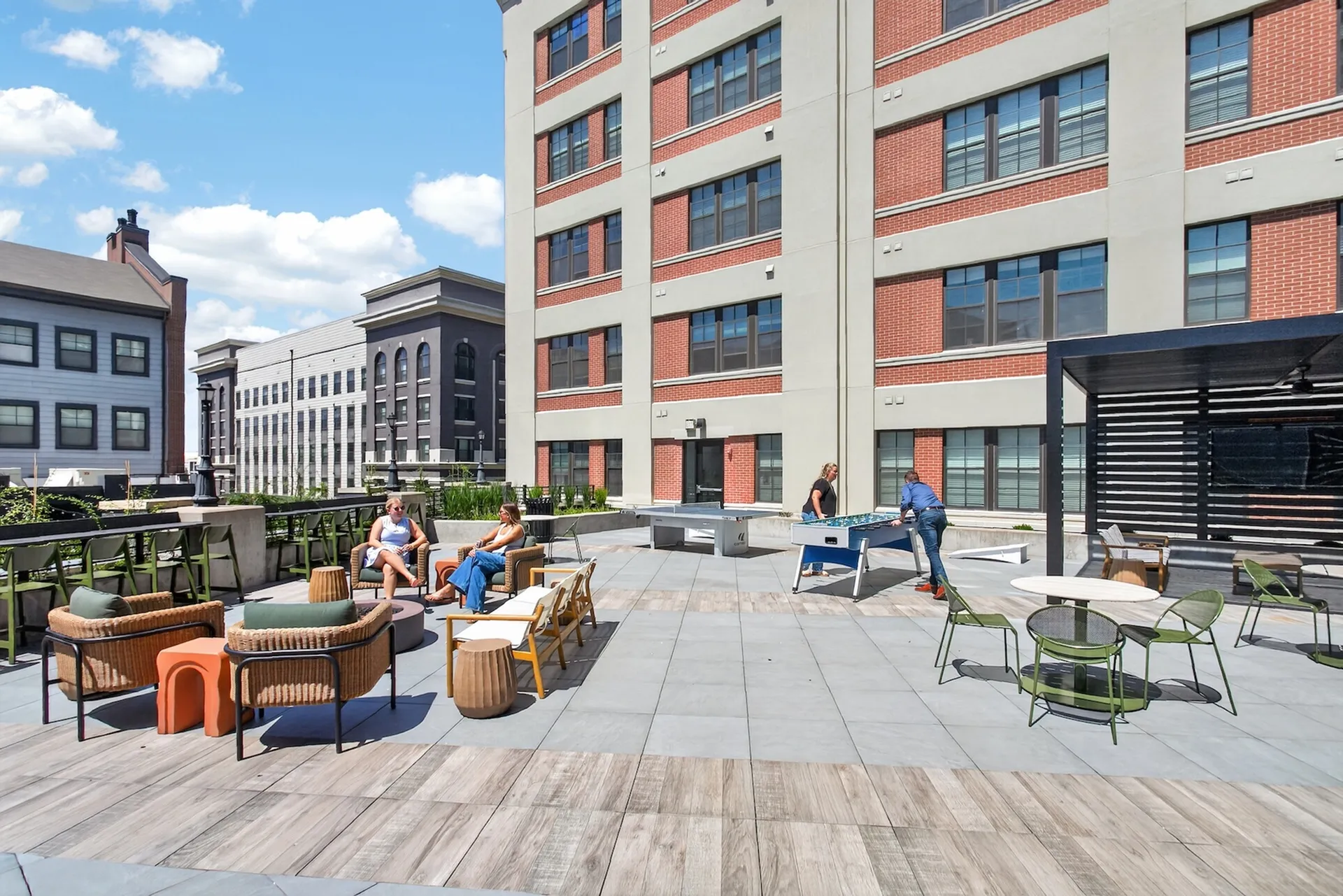 Vibrant rooftop terrace featuring stylish outdoor seating, foosball table, and scenic views, perfect for social gatherings and relaxation.