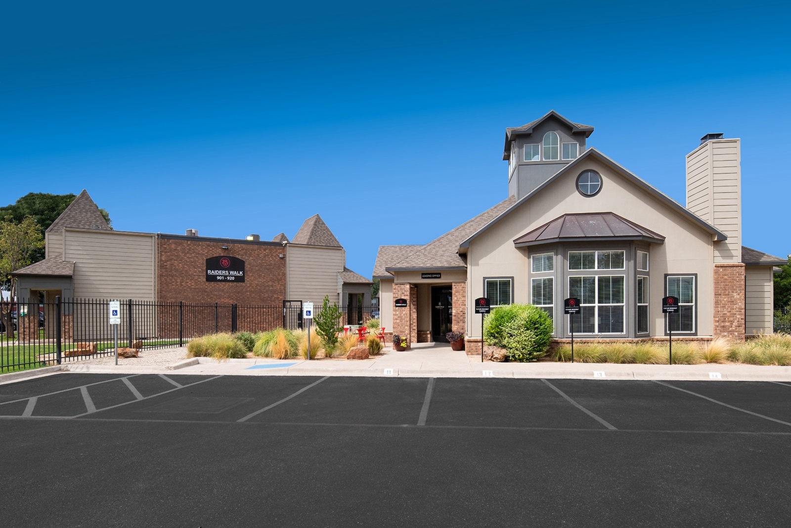 Front of the apartment leasing office with handicap parking space and accessible sidewalk