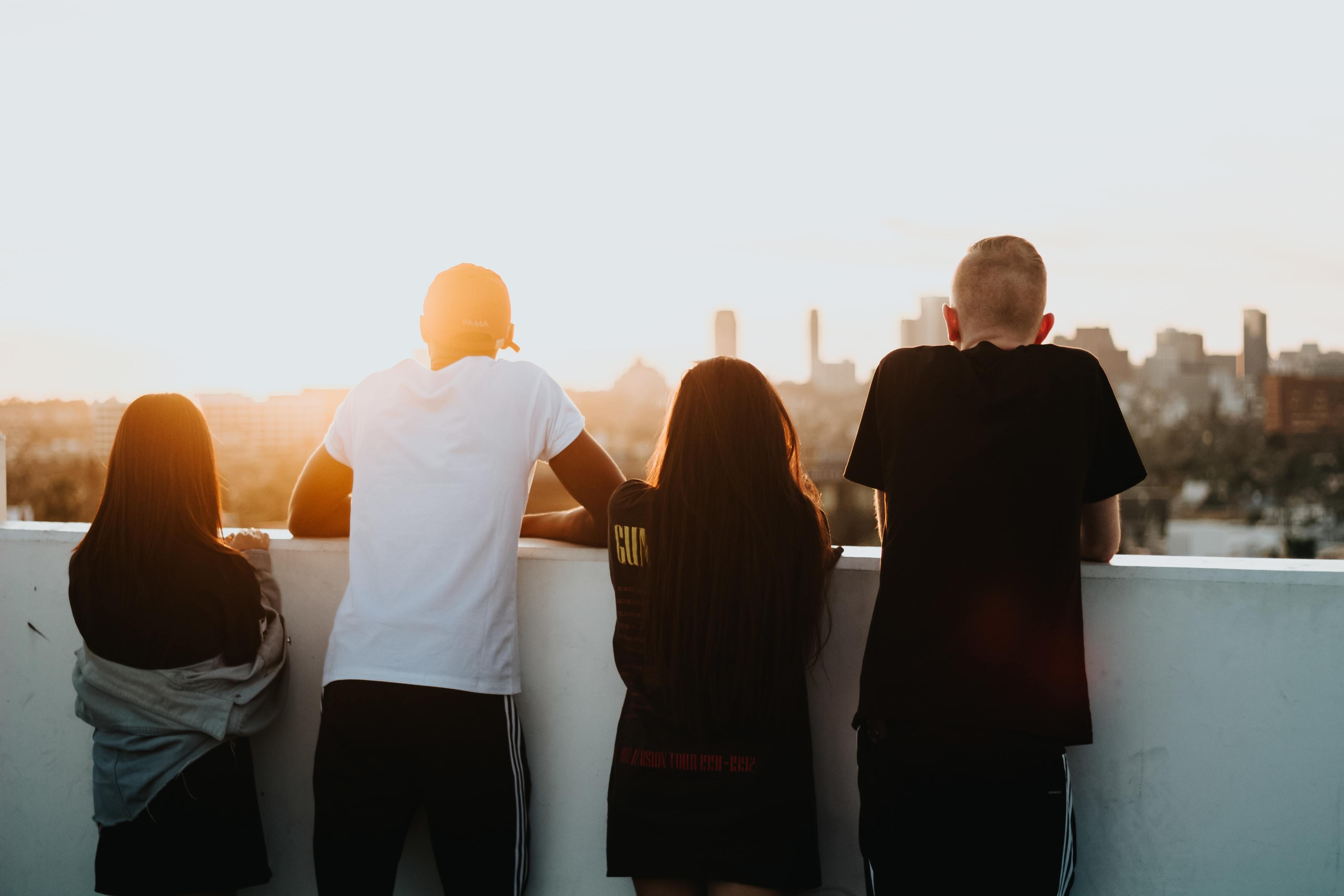 friends on top of a roof enjoying the sunset
