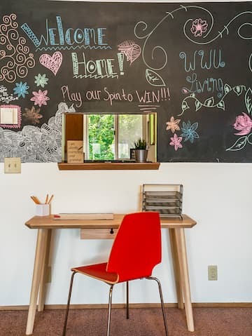 desk and chair in front of a chalkboard wall