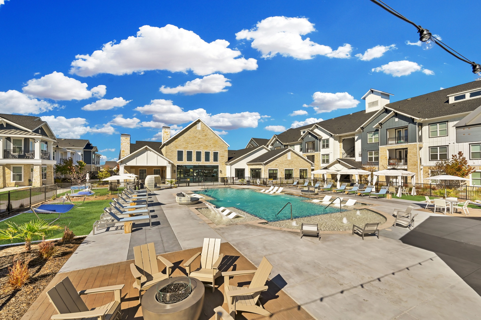 Swimming pool with lounge chairs, hammocks, fire pit, and tables