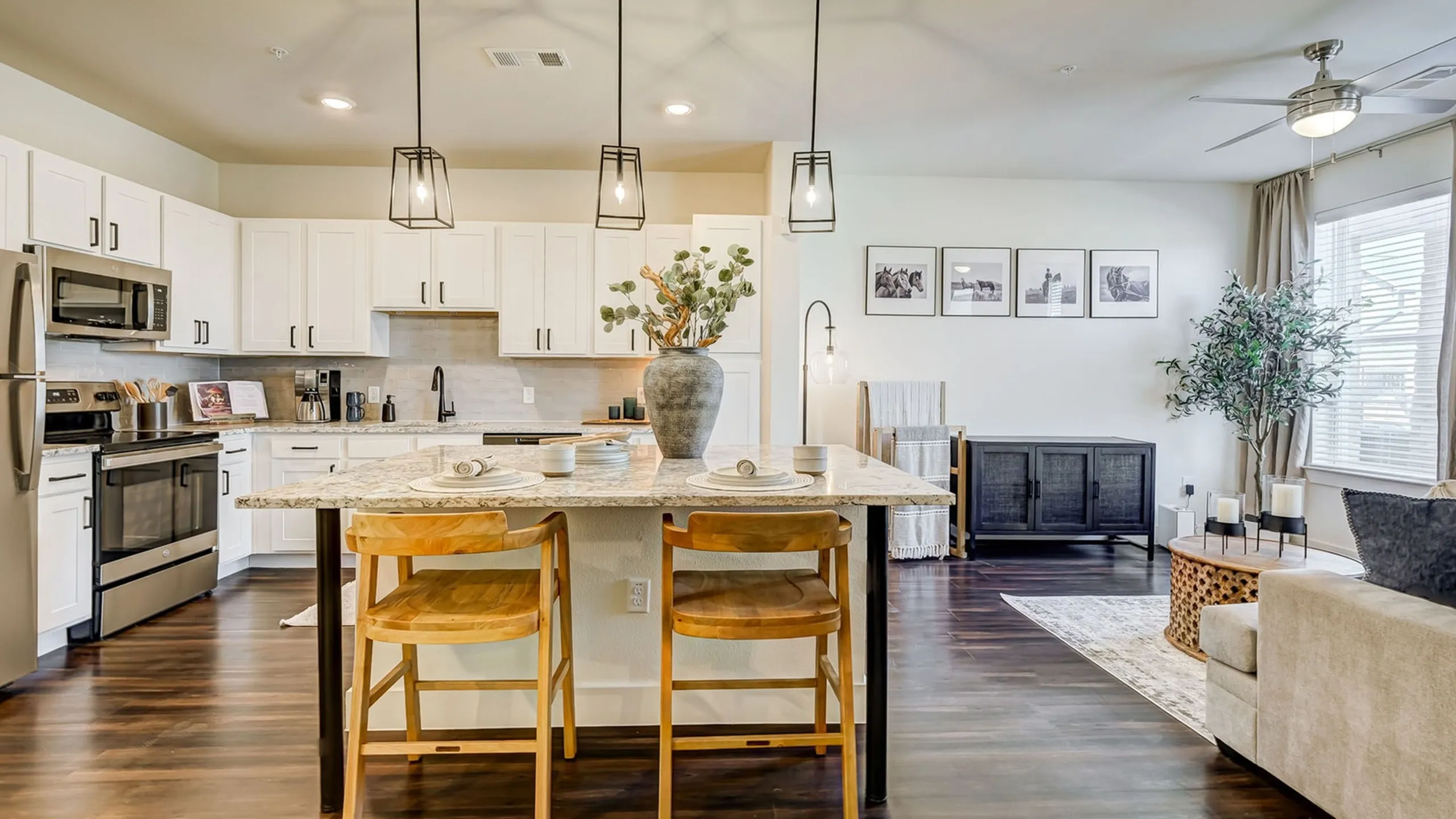 Spacious kitchen with quartz countertops, kitchen island, custom cabinetry, and stainless steel appliances