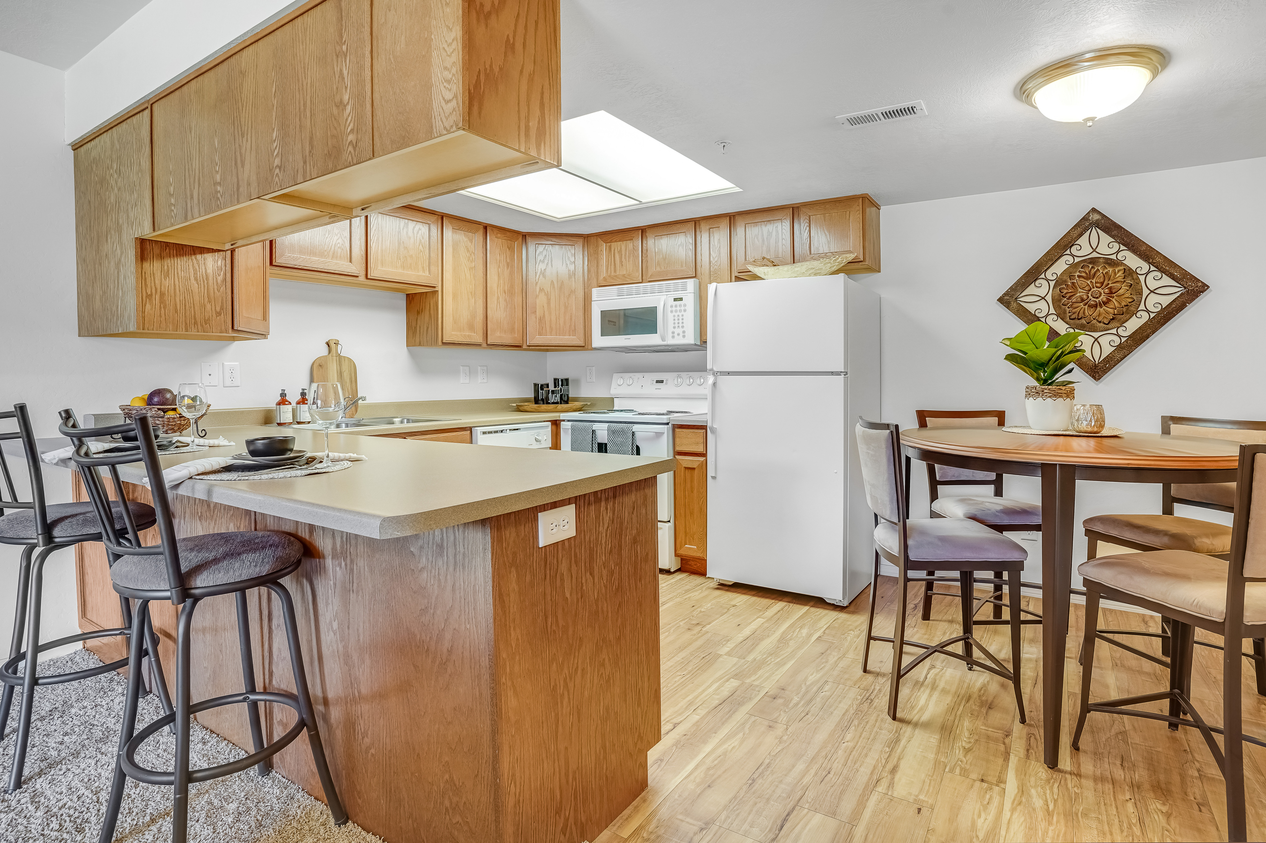 Stylish kitchen featuring modern wooden cabinetry, a cozy dining area, and sleek appliances.