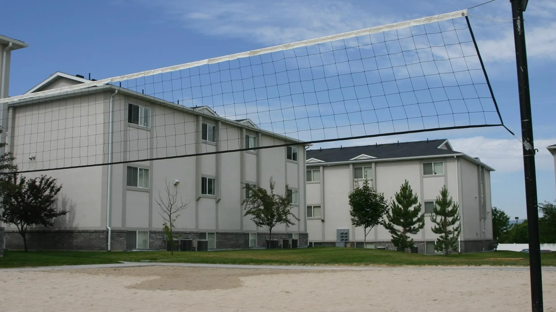 sand volleyball court, sky, apartment buildings