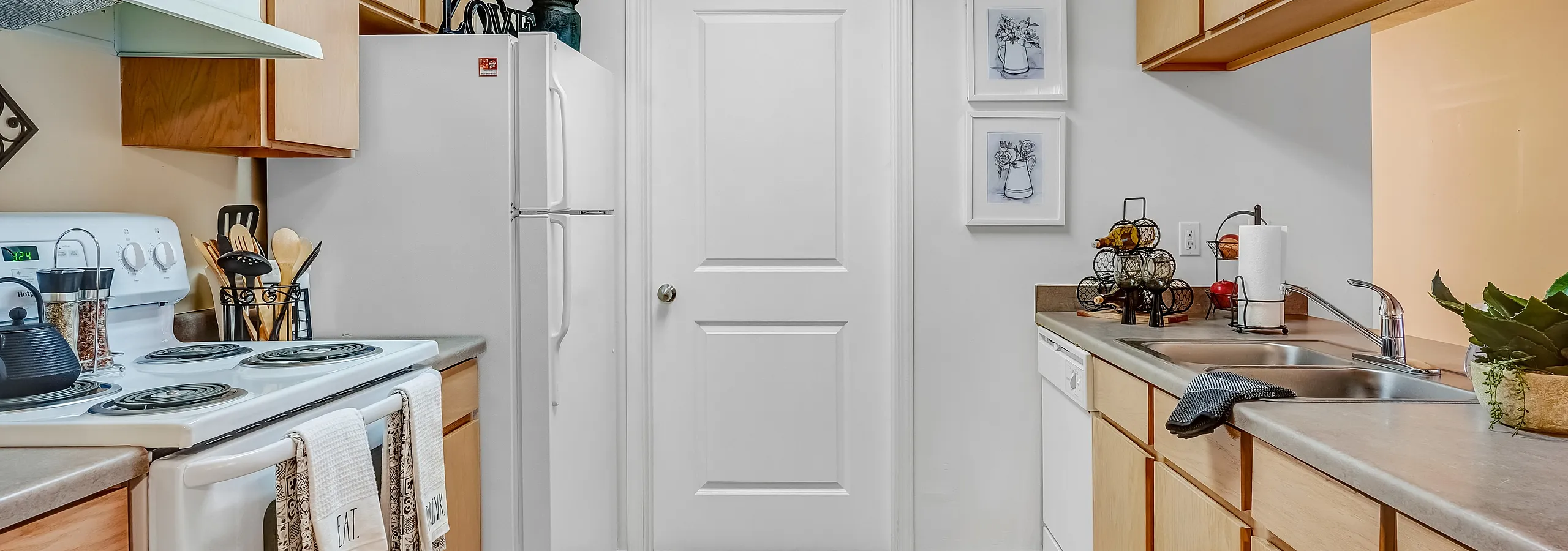 Bright and modern kitchen with wooden cabinets, white appliances, and decorative accents.