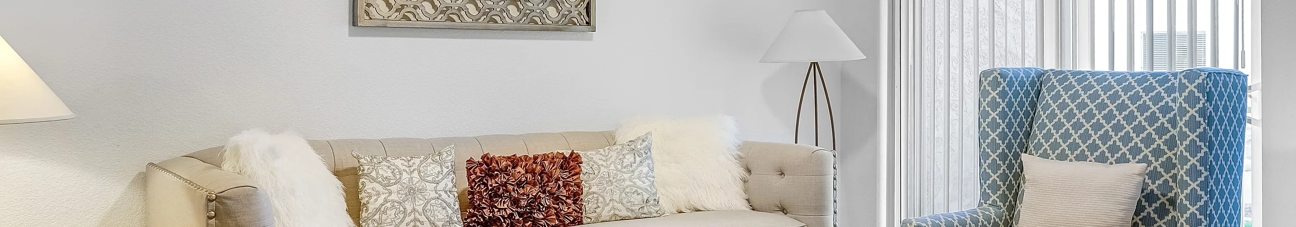 Cozy living room with a stylish sofa, patterned armchairs, and a glass coffee table.